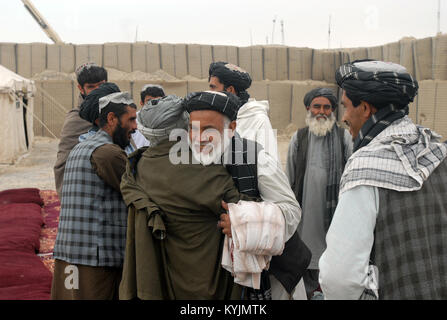 Hajji Faizal Mohammad, Panjwa 'i Governor, begrüßt einen lokalen Bauern zu einem landwirtschaftlichen Shura in Combat Outpost Mushan, Afghanistan, 28. März 2013. Mohammad und einige andere Mitglieder der Regierung der Islamischen Republik Afghanistan an ca. 30 Landwirte, ihre Bedenken und stellte die Gäste mit einfachen Werkzeugen. (U.S. Armee Foto: Staff Sgt. Scott Tynes) Stockfoto