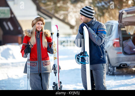 Junge männliche und weibliche Skifahrer in der Liebe auf dem Berg bereit für Skifahren suchen Stockfoto