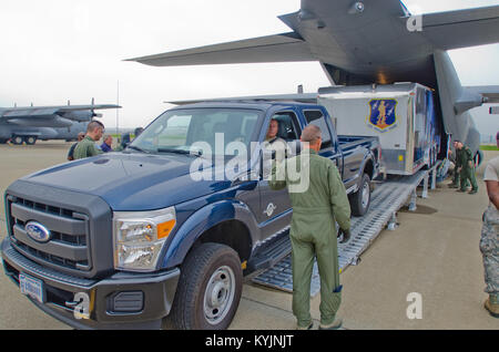 Flieger von der Kentucky Air National Guard Last eines Prototyps mobile Feldküche auf 123 Luftbrücke Flügel C-130 Hercules Flugzeuge am Kentucky Air Guard Base in Louisville, Ky., bei einem Test des Anhängers am 27. Juni 2013. Die Katastrophenhilfe Mobile Küche Trailer kann auf der Website von Naturkatastrophen bereitgestellt werden warme Mahlzeiten für die Helfer zur Verfügung zu stellen. (U.S. Air National Guard Foto von Master Sgt. Phil Speck) Stockfoto