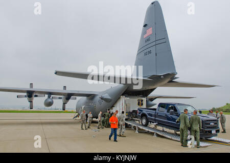 Flieger von der Kentucky Air National Guard Last eines Prototyps mobile Feldküche auf 123 Luftbrücke Flügel C-130 Hercules Flugzeuge am Kentucky Air Guard Base in Louisville, Ky., bei einem Test des Anhängers am 27. Juni 2013. Die Katastrophenhilfe Mobile Küche Trailer kann auf der Website von Naturkatastrophen bereitgestellt werden warme Mahlzeiten für die Helfer zur Verfügung zu stellen. (U.S. Air National Guard Foto von Master Sgt. Phil Speck) Stockfoto