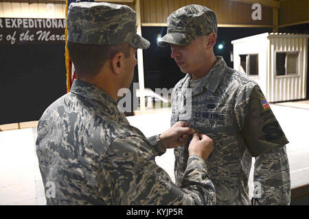 Oberst John Klein jr., 386 Air Expeditionary Wing Commander, Auszeichnungen eine Luftwaffe Leistung Medaille Staff Sgt. Kenneth Soto, 387 Expeditionary Sicherheitskräfte Squadron Response Force Leader, an einem geheimen Ort im Südwesten Asien. Soto, bereitgestellt von der 123 Airlift Wing, Kentucky Air National Guard, wurde die Medaille für seine Antwort präsentiert, während die Pflicht, eine inländische Gewalttätigkeit Vorfall im März 2013. (U.S. Air Force Foto von älteren Flieger Desiree W. Moye) Stockfoto