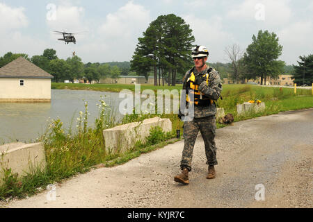 Sgt. Matthäus Marston, ein Soldat um das Ablösen 1, Unternehmen C, 2nd Battalion, 238Th Aviation zugeordnet, Spaziergänge über die Ausbildung an der Städtischen Muscatatuck Training Center nach der Simulation ein Opfer und in eine Blackhawk während der Einheiten auf dem Dach gehisst Extraktion Ausbildung in Butlerville, Ind., am 22. Juli 2016. (U.S. Army National Guard Foto: Staff Sgt. Alexa Becerra) Stockfoto