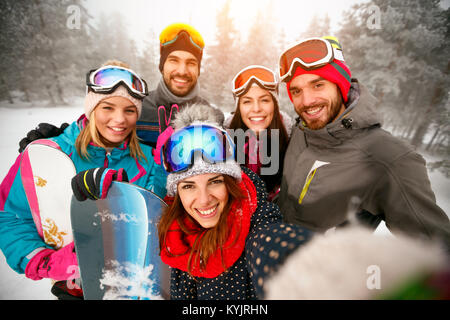 Eine Gruppe von Freunden mit Ski auf Winterurlaub Ski fahren, Spaß auf dem Schnee und selfie Stockfoto