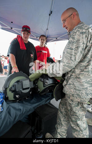 Air Force Maj. Keith Smith, Kommandant der Kentucky der Air National Guard 123 Beseitigung von Explosivstoffen Flug, zeigt EOD Schutzausrüstung ein Fußball-Fan vor Papa John's Cardinal-Stadion in Louisville, Ky., vor der Universität von Louisville - Murray State Football Spiel, Sept. 6, 2014. Das Spiel, berechnet als militärische Anerkennung Tag, begann mit einer Münze durch Luftwaffe Brig ausgeführt werfen. Gen. Warren Hurst, stellvertretender Adjutant General für das Kentucky's National Guard und Kommandant der Texas Air National Guard. (U.S. Air National Guard Foto von Maj. Dale Greer/Freigegeben) Stockfoto