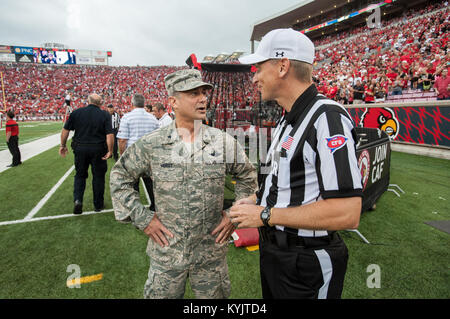 Air Force Brig. Gen. Warren Hurst, stellvertretender Adjutant General für das Kentucky's National Guard und Kommandant der Texas Air National Guard, spricht mit hauptreferent Jeff Heaser am Papa John Cardinal's Stadion in Louisville, Ky., vor der Universität von Louisville - Murray State Football Spiel, Sept. 6, 2014. Das Spiel, berechnet als militärische Anerkennung Tag, begann mit einem Münzwurf Hurst ausgeführt. (U.S. Air National Guard Foto von Maj. Dale Greer/Freigegeben) Stockfoto