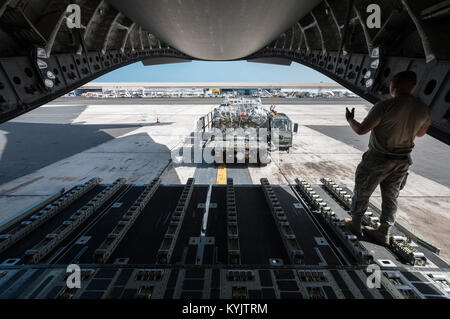 Flieger aus der Kentucky Air National Guard 123. Kontingenz Reaktionsgruppe entlasten Cargo-Paletten aus einer c-17 Globemaster III Flugzeug der 60. Air Mobility Wing, Travis Air Force Base, Kalifornien, als Teil der Rampe Operations bei Léopold Sédar Senghor International Airport in Dakar, Senegal, 18. Oktober 2014, zur Unterstützung der Operation Vereinigte Unterstützung zugewiesen. Die Flieger sind ein Zwischenboden Inszenierung in Dakar um humanitäre Hilfe und militärische Unterstützung Fracht in den betroffenen Gebieten Trichter Betrieb arbeiten im Konzert mit Soldaten aus der US-Armee 689th schnelle Port Öffnungselement einen Join mit Personal Stockfoto