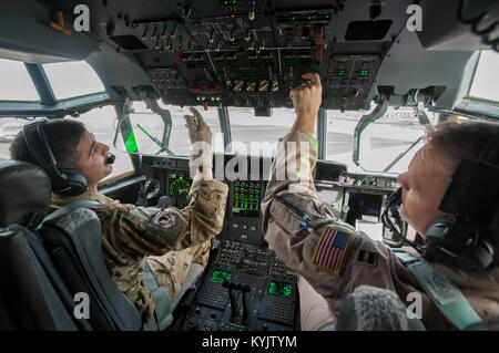 US-Luftwaffe Capts. Führen Sie Vincent Levraea (links) und Jason Steinlicht, beide Piloten aus der 317th Luftbrücke Gruppe Dyess Air Force Base, Texas, Preflight Checklisten bei Léopold Sédar Senghor International Airport in Dakar, Senegal, 4. November 2014. Die Piloten bereiten sich auf einen Ausfall in Monrovia, Liberia, um mehr als 8 Tonnen der humanitären Hilfe und Kriegsmaterial für Operation Vereinigte Unterstützung, der US Agency for International Development geführt, der gesamtstaatliche Anstrengung Ebola-Virus-Ausbruch in Westafrika enthalten liefern zu fliegen. (U.S. Air National Guard Foto von Generalmajor Dal Stockfoto