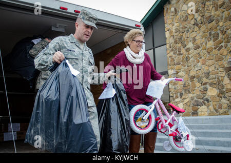 Chief Master Sgt. Ray Dawson (links), command Chief Master Sergeant der 123 Airlift Wing, und Amy Quimby, der Flügel Flieger und Familie Readiness Program Manager, Betrieb Militär jubeln Weihnachten Geschenke an der Kentucky Air National Guard Base in Louisville, Ky., Dez. 17, 2014. Die Geschenke, die durch Anderson Einheit 34 der American Legion Auxiliary in Lawrenceburg, Kentucky gespendet, werden die Kinder in 11 Kentucky Air National Guard Flieger zur Verfügung gestellt werden. (Kentucky Air National Guard Foto von Master Sgt. Phil Speck) Stockfoto