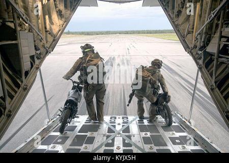 Zwei 123 STS Personal aus Last 50cc mini Bikes auf einer Landebahn auf der Eglin Air Force Base Drop Zone auf der Bühne, vor, um eine statische Zeile zu springen und springen Clearing Team Mission von einem KC-130J Super Hercules vom Marine Antenne Refueler Transport Squadron 252, während Emerald Krieger 2015, 28. April 2015. Der mini Bikes sind zu patrouillieren die Luft strip vor der Landung, um sicherzustellen, dass sich keine Ablagerungen oder feindliche Kräfte in der Nähe der Landing Zone verwendet. Emerald Krieger ist eine gemeinsame Übung unter der Leitung des Air Force Special Operations Command, dass vor der Bereitstellung bietet Training für USA und Partner Nation speci Stockfoto