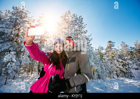 Lächelndes Paar selfie machen und Spaß im Schnee Stockfoto