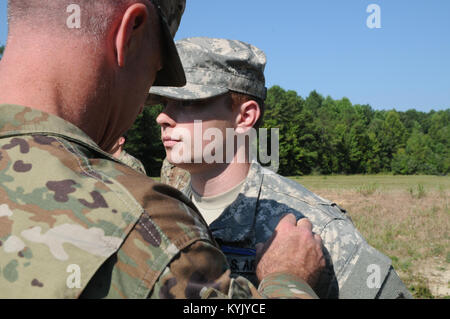 Spc. Adam Dunn rechts), auf das erste Bataillon 149 Infanterie Regiment, Kentucky Nationalgarde zugewiesen, erhält mit der Infanterie Abzeichen von seinem bataillonskommandeur Oberstleutnant Eddie Simpson, Aug. 5 bis Aug.10 am Fort Pickett, Virginia Dunn festgesteckt war einer von drei Kentucky Wachposten die EIB zu erwerben. Stockfoto