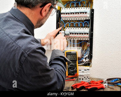 Technische Elektriker zur Festsetzung der Kabel an den Klemmen von Leistungsschalter in einem Wohngebiet elektrischen Bedienfeld Stockfoto