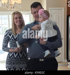 Staff Sgt. Cade Shackelford mit seiner Freundin Erin Diaz und Ihrer 7 Monate alten Tochter Isabella während einer home Einweihung in Lexington, Ky., Jan. 25, 2016. Home Builders Care, der gemeinnützige Arm oder dem Home Builders Association von Lexington die "Heimat für ein Veteran" Shackelford und seine neue Familie gewidmet. (Kentucky National Guard Foto Olivia Burton) Stockfoto