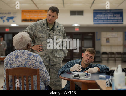 Us Air Force Oberstleutnant Daniel Lau (links), Leiter Krankenschwester aus dem 110 Medical Group, Michigan Air National Guard, spricht mit einem Patienten, während Petty Officer 3rd Class Steven Hanson, einem Krankenhaus Corpsman aus der Expeditionary medizinische Einrichtung der Großen Seen Loslösung V, nach Informationen des Patienten bei Graves County High School in Mayfield, Ky., 18. Juli 2016 schreibt, während der Bluegrass Medical innovative Readiness Training. Während dieser Ausbildung mehrere Air National Guard Einheiten einschließlich der Kentucky Air National Guard, der U.S. Navy, U.S. Army National Guard und Delta regionale Behörde w Stockfoto