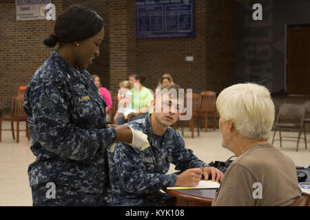 Lt Lunas Ajumobi, eine Krankenschwester in der U.S. Navy Reserve Expeditionary medizinische Einrichtung Bethesda, und Petty Officer 3rd Class Steven Hanson, Hospital corpsman mit der US-Navy Reserve Expeditionary medizinische Einrichtung der Großen Seen eine Loslösung V in Peoria, Illinois, Vitalparameter und Geschichte der Medizin für einen Patienten an Gräbern County High School, Mayfield, Ky., 18. Juli 2016 zu überprüfen. Die Kentucky Air National Guard, zusammen mit anderen Air National Guard Einheiten, und die U.S. Navy Reserve sind, die Ärztliche und zahnärztliche Versorgung ohne Kosten für Bewohner in drei westlichen Kentucky Standorte von Juli 18. bis 27. Die Stockfoto