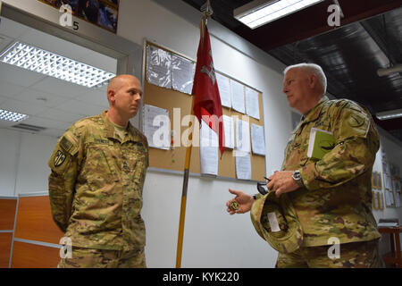 Die Kentucky Direktor des Gemeinsamen Personal Brig. Gen. Benjamin Adams III, Rechts, präsentiert Sgt. 1. Klasse Adam Spencer der 207 horizontale Bauunternehmen mit einer Münze Mar.4 bei seinem Besuch in Camp Arifjan, Kuwait. Stockfoto