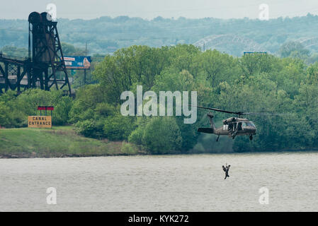 Ein Kentucky Army National Guard UH-60 Blackhawk Hebezeuge Flieger von der Kentucky Air Guardâs 123 Spezielle Taktiken Squadron in das Flugzeug nach Durchführung einer simulierten Rescue Mission in den Ohio River in Louisville, Ky., 22. April 2017. Die Demonstration war Teil des Donners über Louisville, eine jährliche Air Show, zieht Tausende von Zuschauern an den Ufern des Ohio. (U.S. Air National Guard Foto von Oberstleutnant Dale Greer) Stockfoto