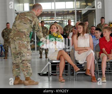 Die 63 Theater Aviation Brigade Soldat des Jahres, SPC. James E. Alvey Geschenke Blumen an die eingehenden Kommandeur, Oberstleutnant Gary D. Lewis' Frau, Frau Sheri Lewis, während eine Änderung der Befehl Zeremonie in Frankfort, Ky., 20. Mai 2017 statt. Stockfoto