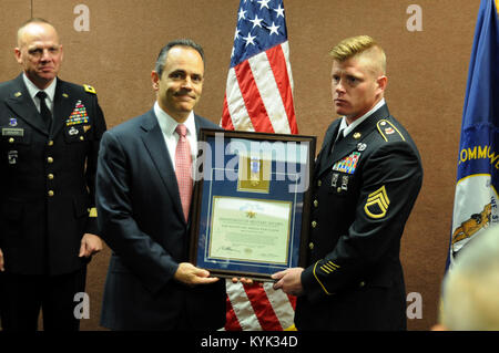 Gouverneur Matt Bevin und Kentucky National Guard Adjutant General, Armee Generalmajor Stephen R. Hogan an Hand award Staff Sgt. Michael R. Tester, eine Versorgung Unteroffizier mit dem Alpha Batterie dienen, 1.BATAILLON, 623Rd Field Artillery Regiment, Kentucky Army National Guard, die Kentucky Medaille für Valor für seine Aktionen im September letzten Jahres während dieser Jahre National Guard Konferenz an der Kentucky Expo Center in Louisville, Ky., Sept. 8, 2017. (U.S. Army National Guard Foto von Personal. Sgt. Benjamin Kran) Stockfoto