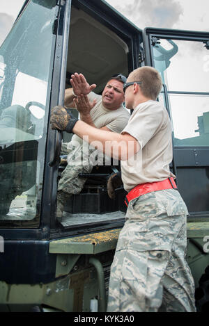 Staff Sgt. John kann eine Antenne Porter von 123. Die Kentucky der Air National Guard Contingency Response Group, erläutert Cargo Handling mit einer anderen Antenne porter Okt. 7, 2017, Luis Muñoz Marín International Airport in San Juan, Puerto Rico. Der Mai ist mit mehr als 7,2 Millionen Pfund der humanitären Hilfe hier verarbeitet seit Sept. 23 in der von Hurrikan Maria. (U.S. Air National Guard Foto von Oberstleutnant Dale Greer) Stockfoto