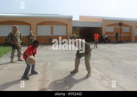 1. Lt. Derek Fosson mit der 940Th Military Police Company spielt Basketball mit einem einheimischen Jungen Tierheim in St. Thomas, USVI May, 19, 2017.) (USA Army National Guard Foto von Sgt. Tosha Cobler) Stockfoto