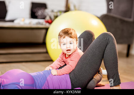 Baby Sohn mit Mutter exercing zu Hause Stockfoto