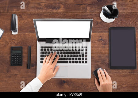 Ansicht der Kaufmann mit Laptop mit leeren weißen Bildschirm auf dem Schreibtisch Stockfoto