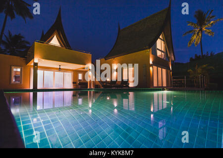 Wunderschöne luxuriöse Villa in der Dämmerung, luxuriöse private teuer Haus mit Swimmingpool, asiatischen Stil Außenfassade Stockfoto