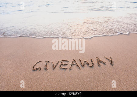 Give-away, Wort Meldung am Sand geschrieben Stockfoto