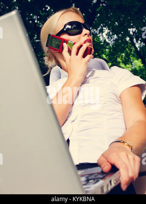 Attraktive junge Frau Berufung durch Mobiltelefon Stockfoto