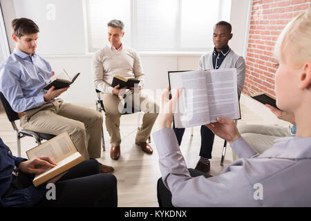 Nahaufnahme einer Frau liest Bibel in Gruppe Stockfoto