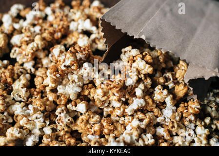 Frische Karamell Popcorn in eine Papiertüte auf hölzernen Tisch