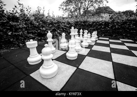 Schachspiel mit großen Stücke in einen Garten in Monochrome Farben Stockfoto