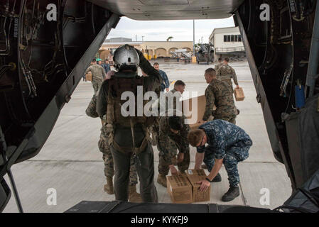 SAN JUAN, Puerto Rico (Sept. 25, 2017) Matrosen und Marines an der 26 Marine Expeditionary Unit (26 MEU), an Bord der Amphibisches Schiff USS Kearsarge (LHD 3), militärischen Bereich Rationen, bekannt als MRE oder Mahlzeiten, bereit zu essen, aus einer MV-22 Osprey Flugzeug am internationalen Flughafen Luis Munoz Marin in San Juan, Puerto Rico entladen. Kearsarge und der 26 MEU unterstützen mit Hilfsmaßnahmen in den Wirbelsturm Maria. Das Verteidigungsministerium ist die Unterstützung der Federal Emergency Management Agency, die federführende Bundesbehörde, dabei helfen, die Betroffenen durch den Hurrikan Maria Stockfoto