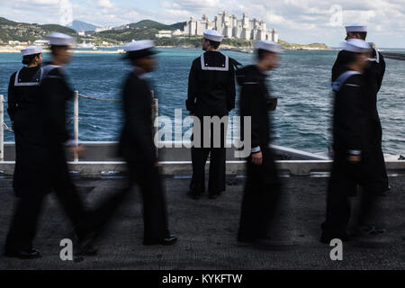 Gewässer ÖSTLICH DER KOREANISCHEN HALBINSEL (Okt. 2010) 21, 2017) U.S. Navy Matrosen an Bord der Vorwärts - bereitgestellt Flugzeugträger USS Ronald Reagan (CVN 76), die Schienen auf dem Flugdeck der Mensch als das Schiff kommt für einen geplanten Hafen besuch in Busan, Korea. Der Hafen besuchen kommt nach Routinebetrieb in den Gewässern vor der Küste von der Koreanischen Halbinsel. Ronald Reagan, das Flaggschiff der Carrier Strike Group 5, bietet eine Bekämpfung bereit, Kraft, schützt und verteidigt die kollektive maritime Interessen seiner Verbündeten und Partnern in der Indo-Asia-Pazifik-Region. (U.S. Marine Foto von Massenkommunikation Speciali Stockfoto