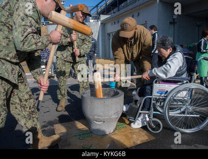 SASEBO, Japan (31. 15, 2017) Matrosen zu Naval Beach Einheit 7 helfen die Bewohner der Nijiiro herausgefordert Home pound Mochi als Teil eines Chief Pett Ofiicer (CPO) 365 und Kommandant, Flotte Aktivitäten Sasebo Chaos Leiter zugeordnete led Community Service besuchen. Mochi ist ein japanisches Essen aus Reis schlug in Teig und rollte in Knödel. Stampfende mochi ist eine Japanische New Year's Tradition. (U.S. Marine Foto von Mass Communication Specialist 1. Klasse David R. Krigbaum/Freigegeben) 171215-N-QY 759-0069 Stockfoto