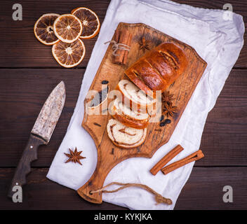 Gebackene Brötchen mit Zimt und Nüsse auf Holz Schneidbrett, Messer, Ansicht von oben Stockfoto
