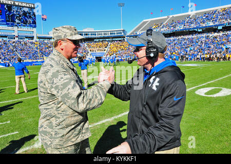 Die Kentucky Adjutant General, Generalmajor Edward W. Tonini grüßt Universität von Kentucky Fußball-Cheftrainer, Mark Stoops im Commonwealth Stadium in Lexington, Ky. November 9, 2013. (U.S. Army National Guard Foto: Staff Sgt. Scott Raymond) Stockfoto