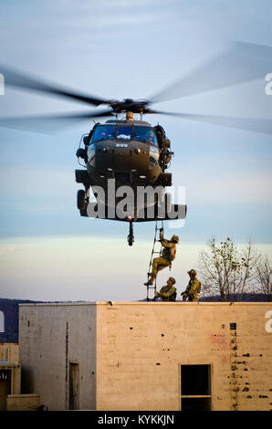 Mitglieder der 123 Spezielle die Kentucky der Air National Guard Taktiken Squadron klettern eine Strickleiter auf ein Kentucky Army National Guard UH-60 Blackhawk während der Ausbildung bei zussman Palette an Fort Knox, Ky., Nov. 21, 2013. Die Flieger waren üben Einfügungen, Extraktionen und close-Quarters Combat in einem simulierten Afghanischen Dorf. (U.S. Air National Guard Foto von Master Sgt. Phil Speck) Stockfoto