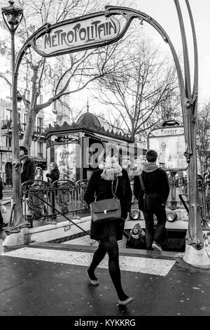 PARIS - Jan 2, 2014: Lokale Parisern zu Fuß rund um den berühmten Place Pigalle metro Eingang, mit unverwechselbaren Jugendstil Eisen Rahmen. Schwarz und Weiß Stockfoto