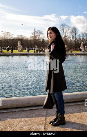 PARIS - Jan 2 2014: Eine unbekannte Frau in einem Winter Fell steht durch den Teich am Jardin des Tulieries, einem der beliebtesten Reiseziele in Par Stockfoto