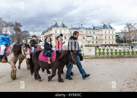 PARIS, Frankreich - Jan 4, 2014: Kinder fahren Ponys an den Luxemburg Gärten. Stockfoto