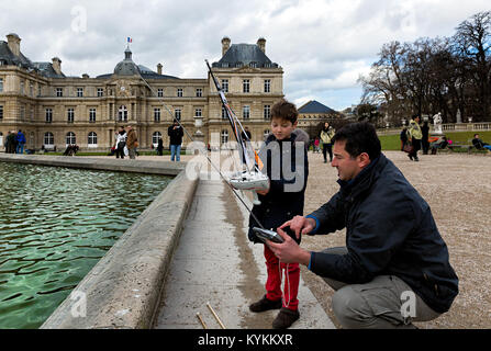 PARIS, Frankreich - Jan 4, 2014: Eine nicht identifizierte Kind lernt, wie ein Modell Boot an der Jardin du Luxembourg, der zweitgrößte Park in Paris, sehr po zu segeln Stockfoto