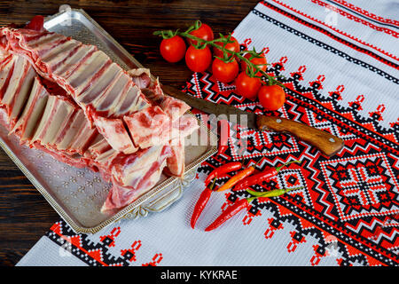 Lamm, Hammel mit Gewürzen, roter Pfeffer, Knoblauch und Zwiebeln auf Schiefer und Holz- Tabelle. Ansicht von oben. Stockfoto