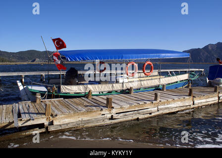 Lange Motorboot in der Nähe von Pier auf dem Fluß Dalyan, Türkei Stockfoto