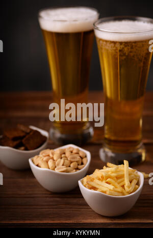 Pub Bier Snacks. Kartoffelstifte, gesalzene Erdnüsse und Roggen Knoblauch Croutons. Stockfoto