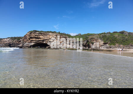 Höhlen Strand ist südlich von Swansea Köpfe in der Newcastle Region liegt. Es ist ein wunderschöner Strand mit einigen Höhlen in den Felsen am südlichen Stockfoto