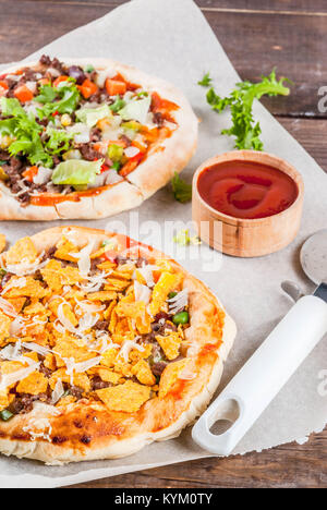 Hausgemachte PIzza mit Nachos mexikanischen Taco Chips, Bohnen, frischem Gemüse, Rindfleisch, Kopie Raum Stockfoto