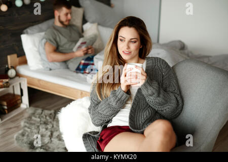 Schuß von verträumten Frau trinkt Kaffee am Morgen in einem Sessel Stockfoto