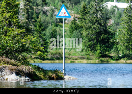 Warnung Schild stand neben den See in Norwegen zeigt, dass die Person, die in das Wasser vom Wind ausgeblasen werden kann. Stockfoto